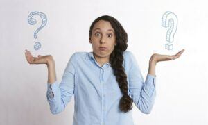 woman shrugging shoulders with two questions marks in the palms of her hands