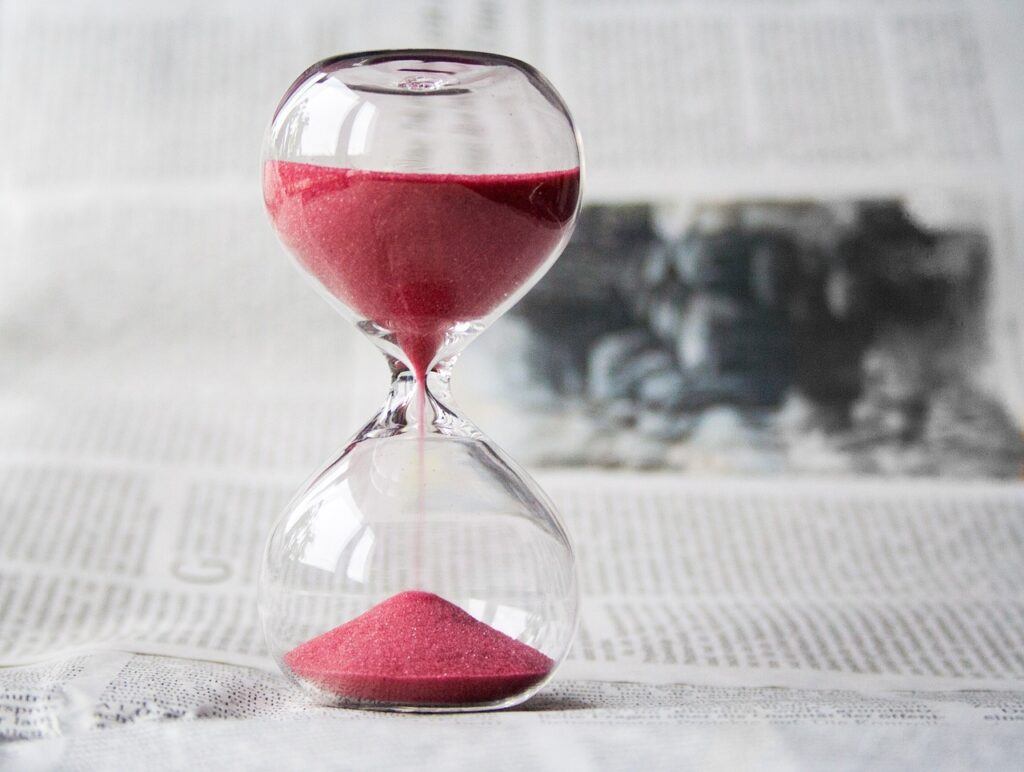 clear hourglass running with pink sand