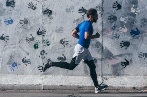 man running past a wall full of handprints