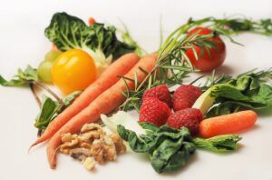 yellow bell pepper, carrots, strawberries, tomato, and nuts placed together