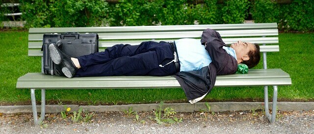 man on park bench struggling to get good sleep