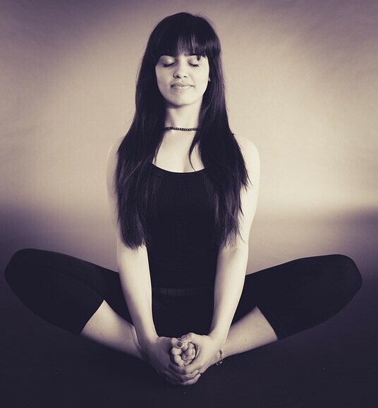 woman calmly mediating with yoga