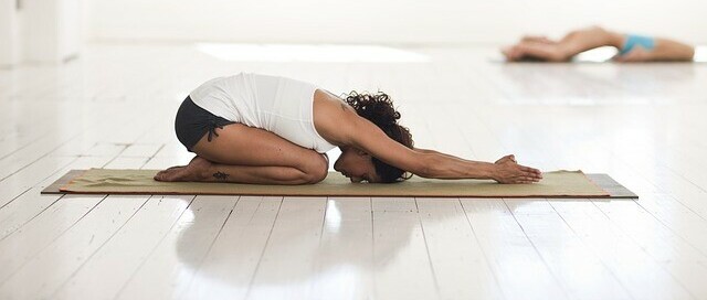 woman performing yoga with the child's pose relaxing to do while fasting