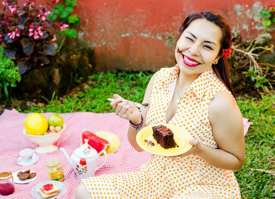 woman smiling while eating a chocolate cake